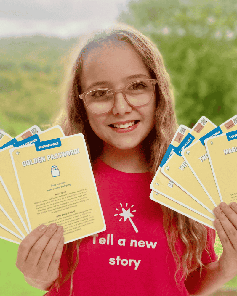 Girl in a red T-shirt holding several Superpower Cards with trees in the background