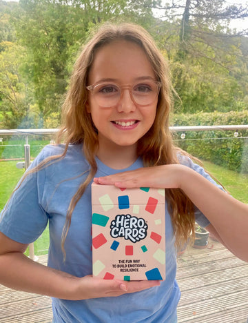 Girl holding a box of Hero Cards outdoors